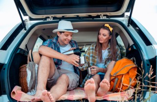 immagine di una coppia appassionata di viaggi on the road, che fanno un picnic in macchina