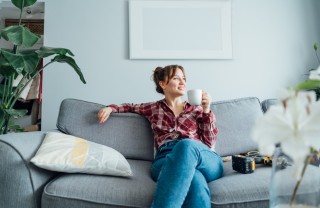 Una donna si rilassa sul divano equità di genere in casa, home gender equality