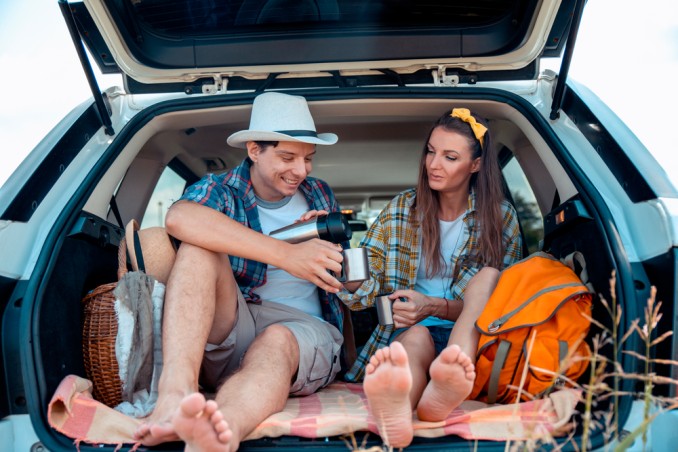 immagine di una coppia appassionata di viaggi on the road, che fanno un picnic in macchina